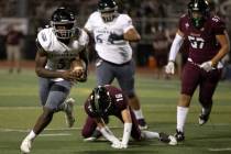 Desert Pines running back Greg Burrell (5) evades tackle from Faith Lutheran fast safety Matthe ...