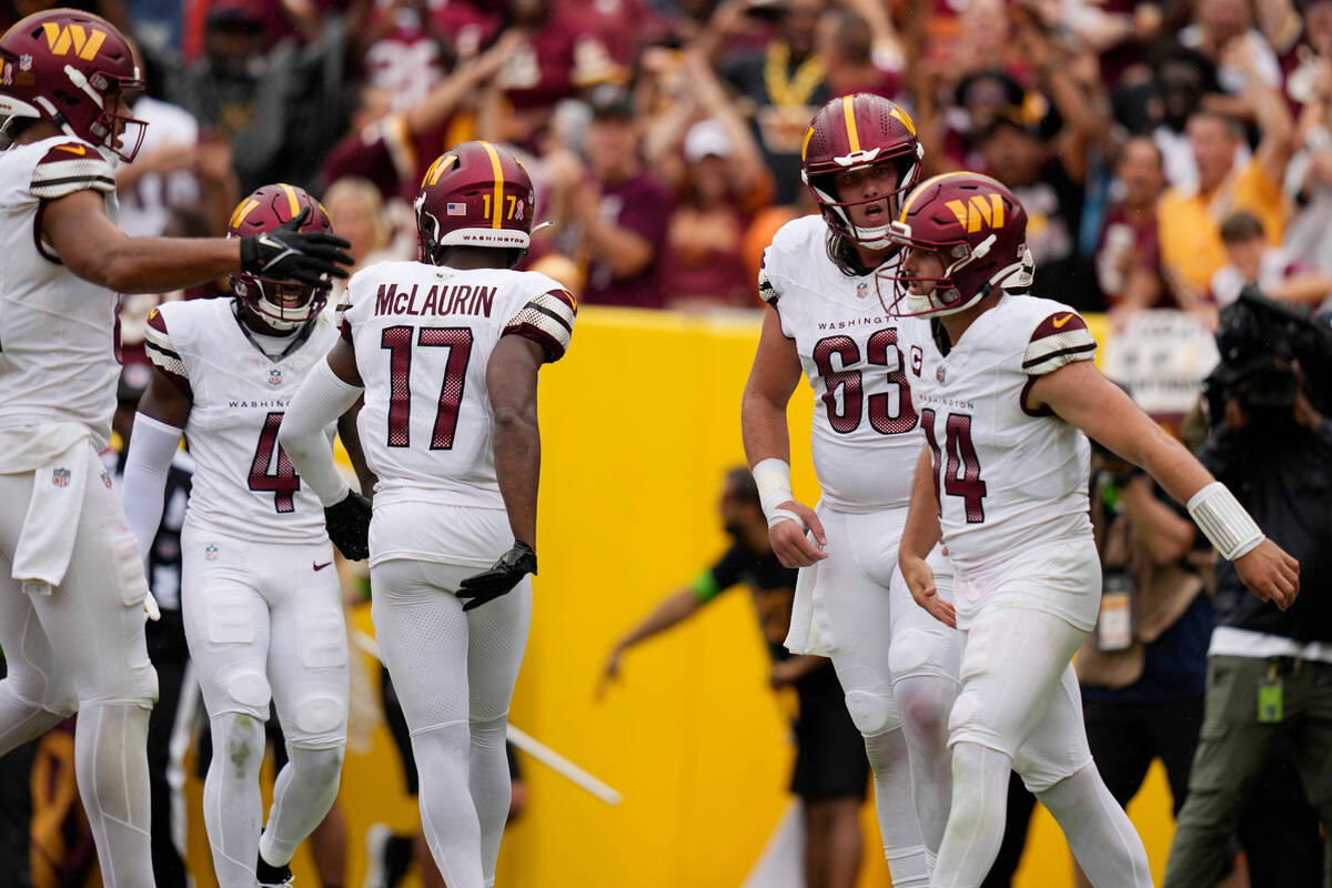 Washington Commanders quarterback Sam Howell (14) celebrates running in for a touchdown with te ...