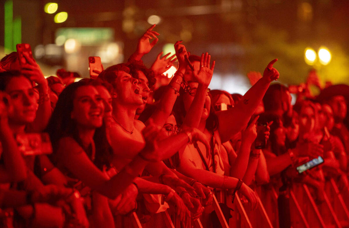 Fans bathed in red light cheer for Tame Impala performing on the Downtown Stage during day one ...