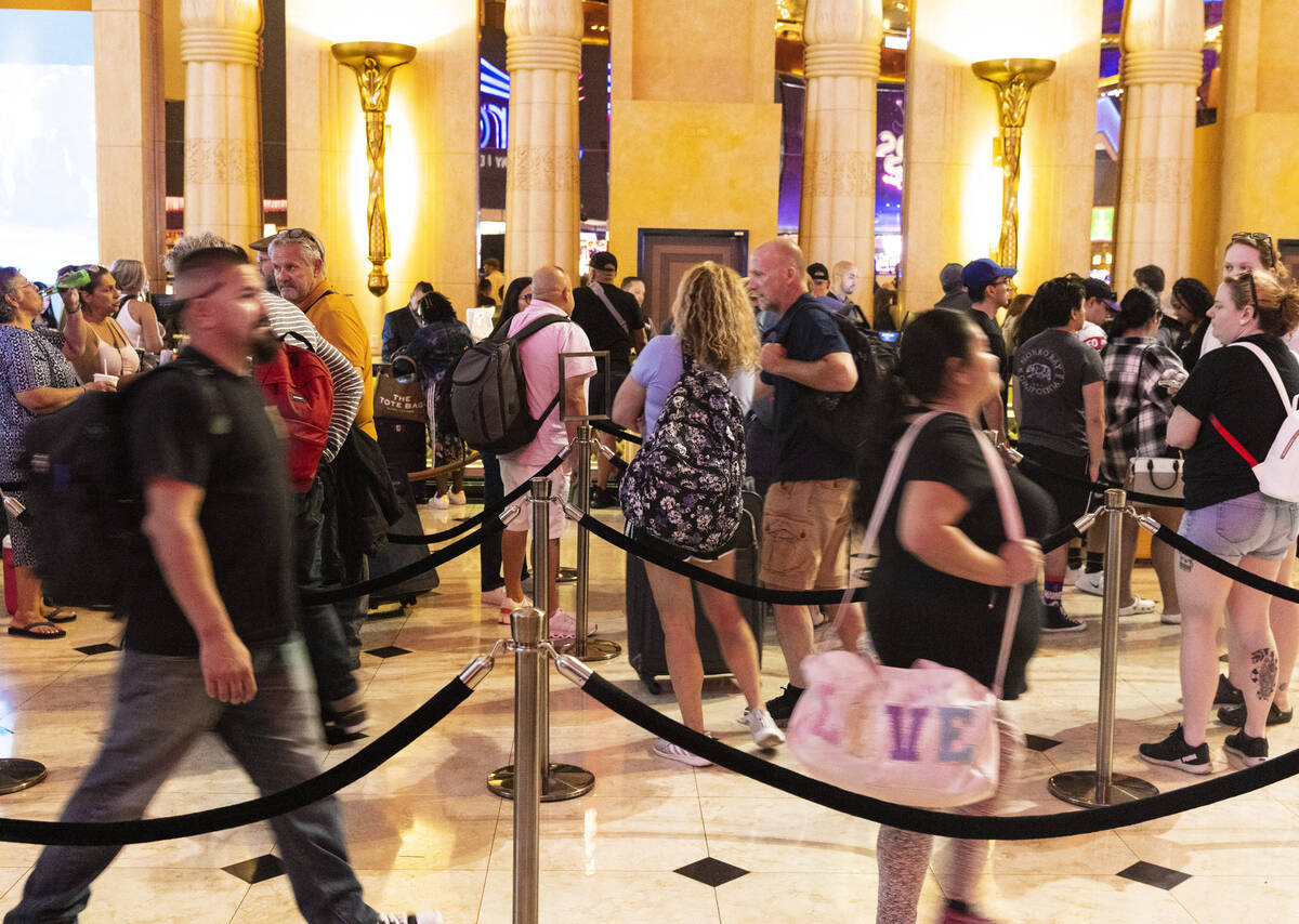Hotel guests wait in line as they check in at Luxor hotel-casino, on Thursday, Sept. 14, 2023, ...