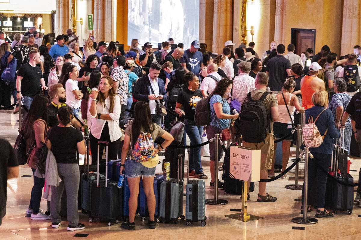 Hotel guests wait in line as they check in at Luxor hotel-casino, on Thursday, Sept. 14, 2023, ...