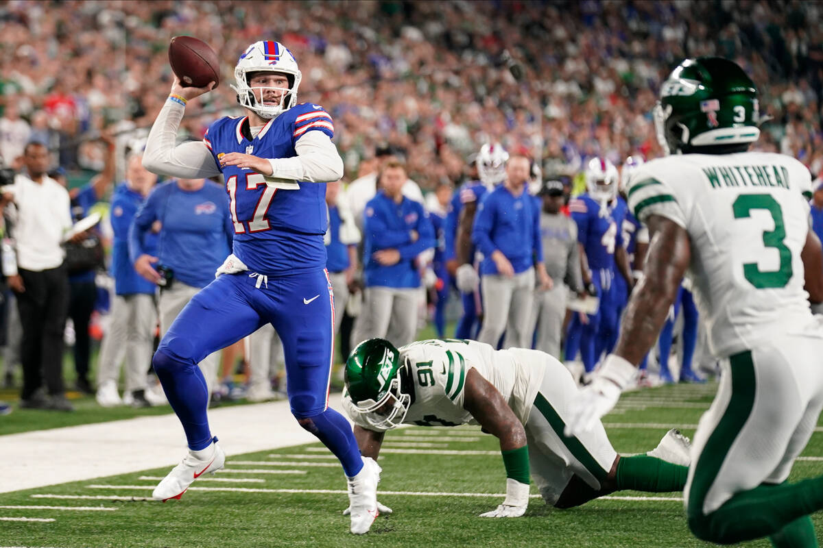 Buffalo Bills quarterback Josh Allen (17) throws under pressure from New York Jets defensive en ...