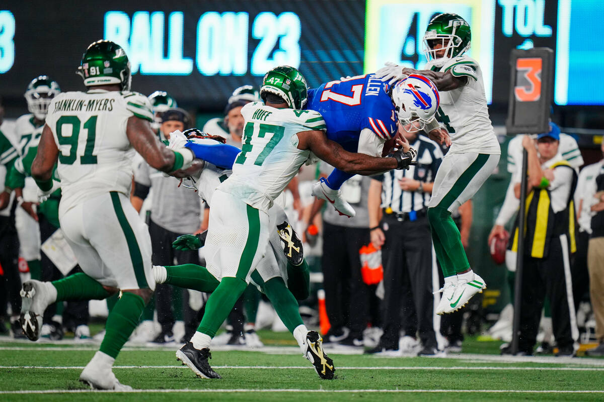 Buffalo Bills quarterback Josh Allen (17) leaps into the defense of New York Jets defensive end ...