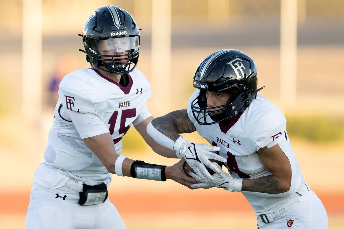 Faith Lutheran quarterback Alex Rogers (15) hands the ball off to running back Cale Breslin (14 ...