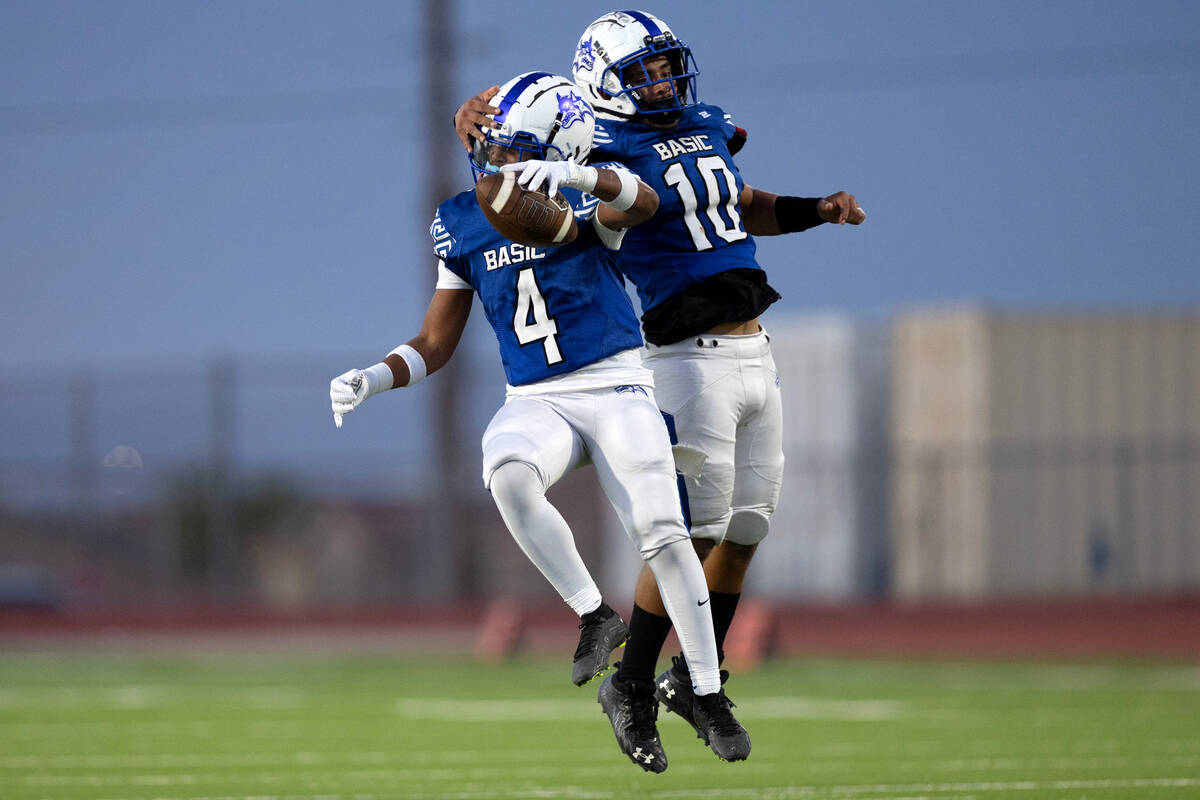 Basic cornerback Chris Smith (4) celebrates after catching an interception with linebacker Anth ...
