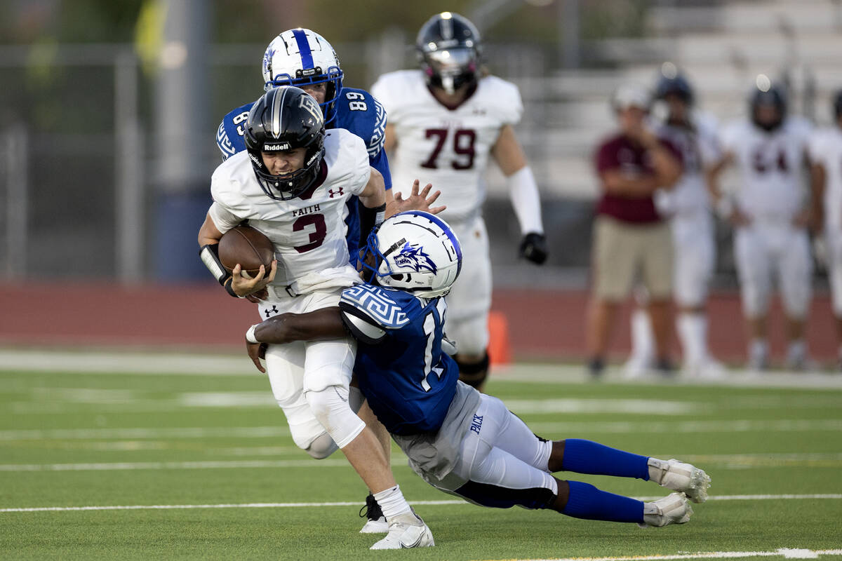 Faith Lutheran quarterback Garyt Odom (3) is tackled on by Basic’s Jaiden Forby (13) dur ...