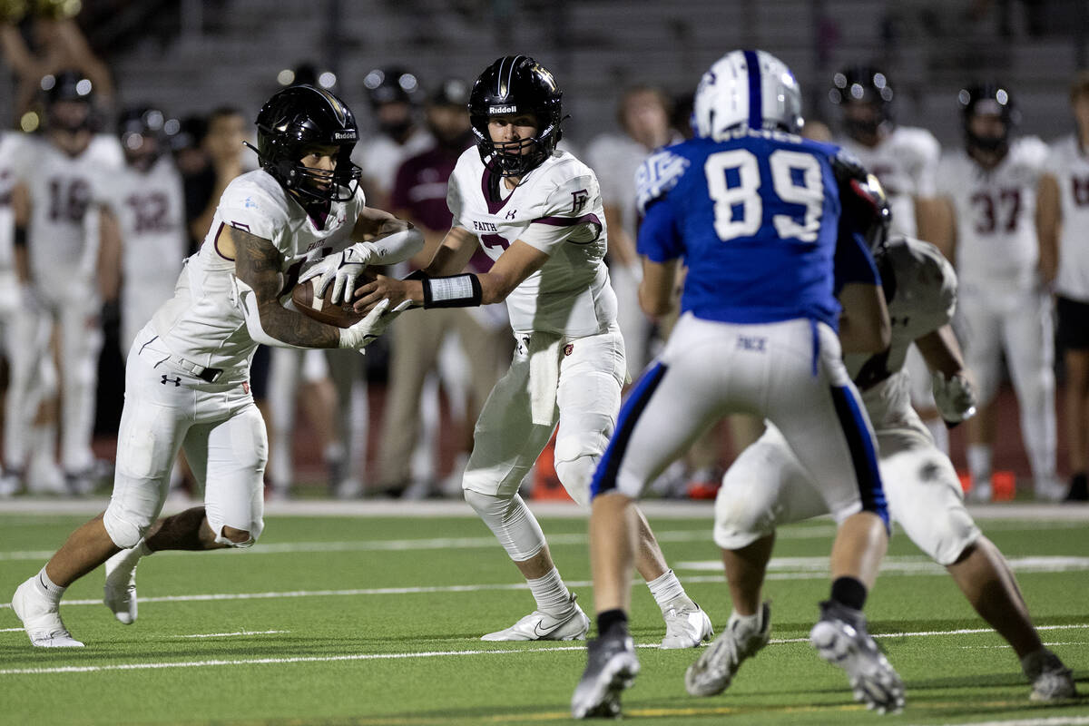 Faith Lutheran quarterback Garyt Odom (3) hands the ball off to running back Cale Breslin (14) ...