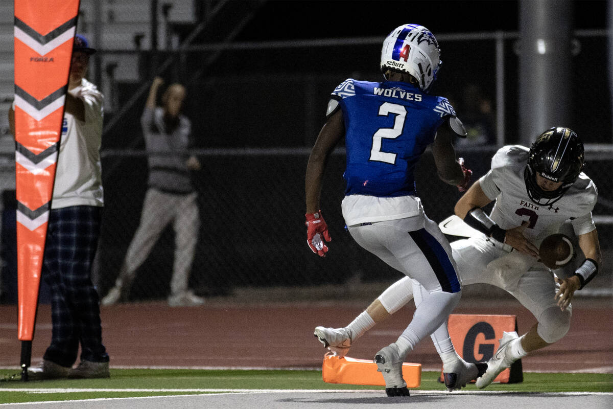 Faith Lutheran quarterback Garyt Odom (3) falls into the end zone for a touchdown while Basic w ...
