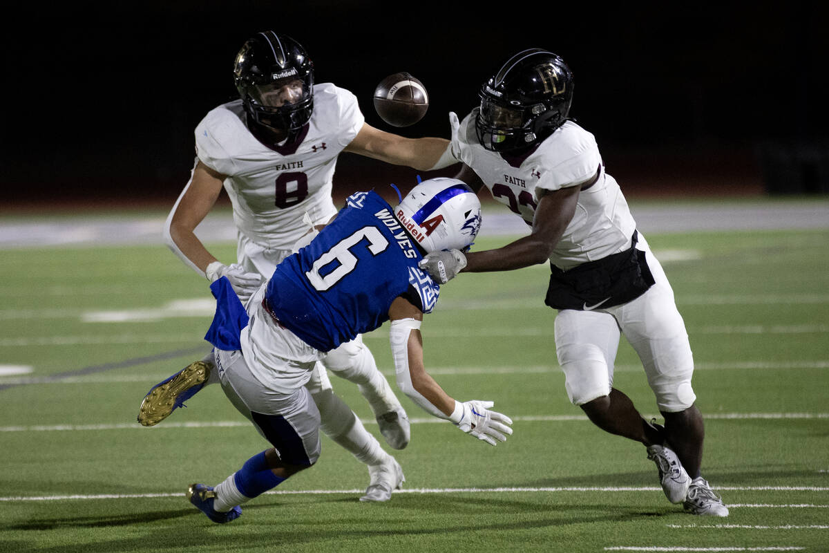 Faith Lutheran tight end Cole Keith (8) and cornerback Wandley Wilson (23) tackle Basic wide re ...