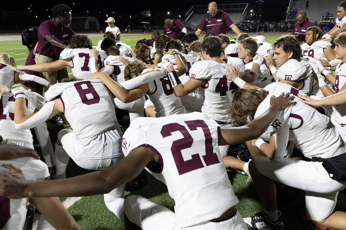 Faith Lutheran says a prayer after their team won a high school football game in overtime again ...
