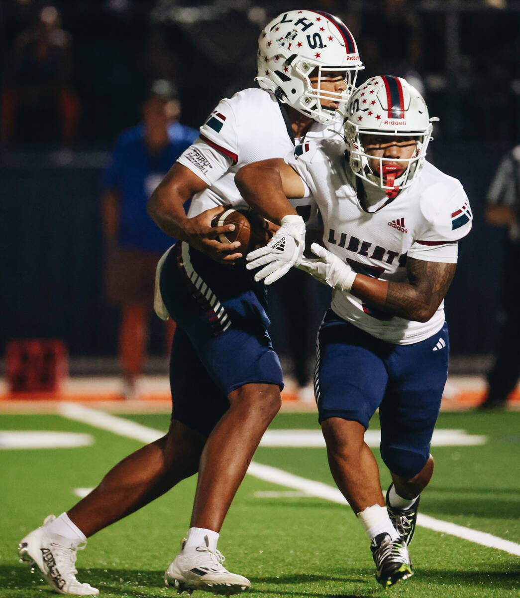 Liberty quarterback Tyrese Smith (11) pretends to pass the ball to running back Isaiah Lauofo ( ...
