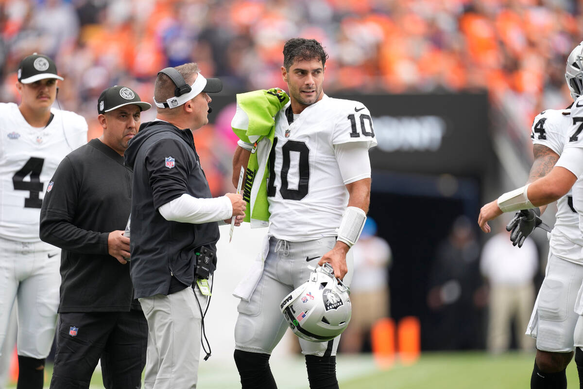 Las Vegas Raiders head coach Josh McDaniels confers with quarterback Jimmy Garoppolo (10) in th ...