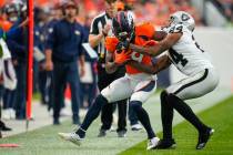 Denver Broncos wide receiver Marvin Mims Jr. (19) is tackled by Las Vegas Raiders cornerback Ma ...