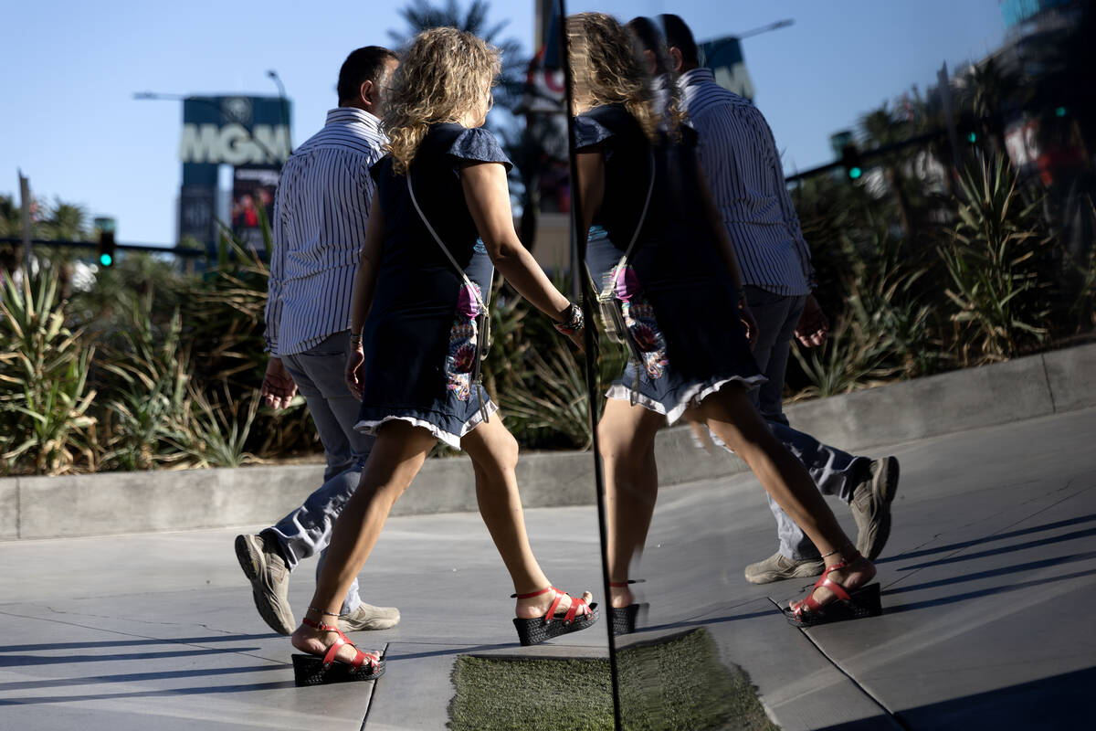 Pedestrians walk down Las Vegas Boulevard with the MGM Grand marquee in the background on Frida ...