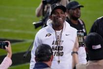 Colorado head coach Deion Sanders, center, stops and pulls off his sunglasses and smiles for th ...