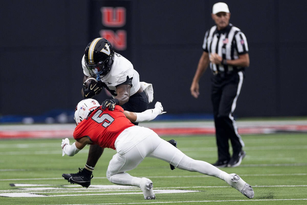 UNLV defensive back Cameron Oliver (5) tackles Vanderbilt running back Patrick Smith (4) during ...