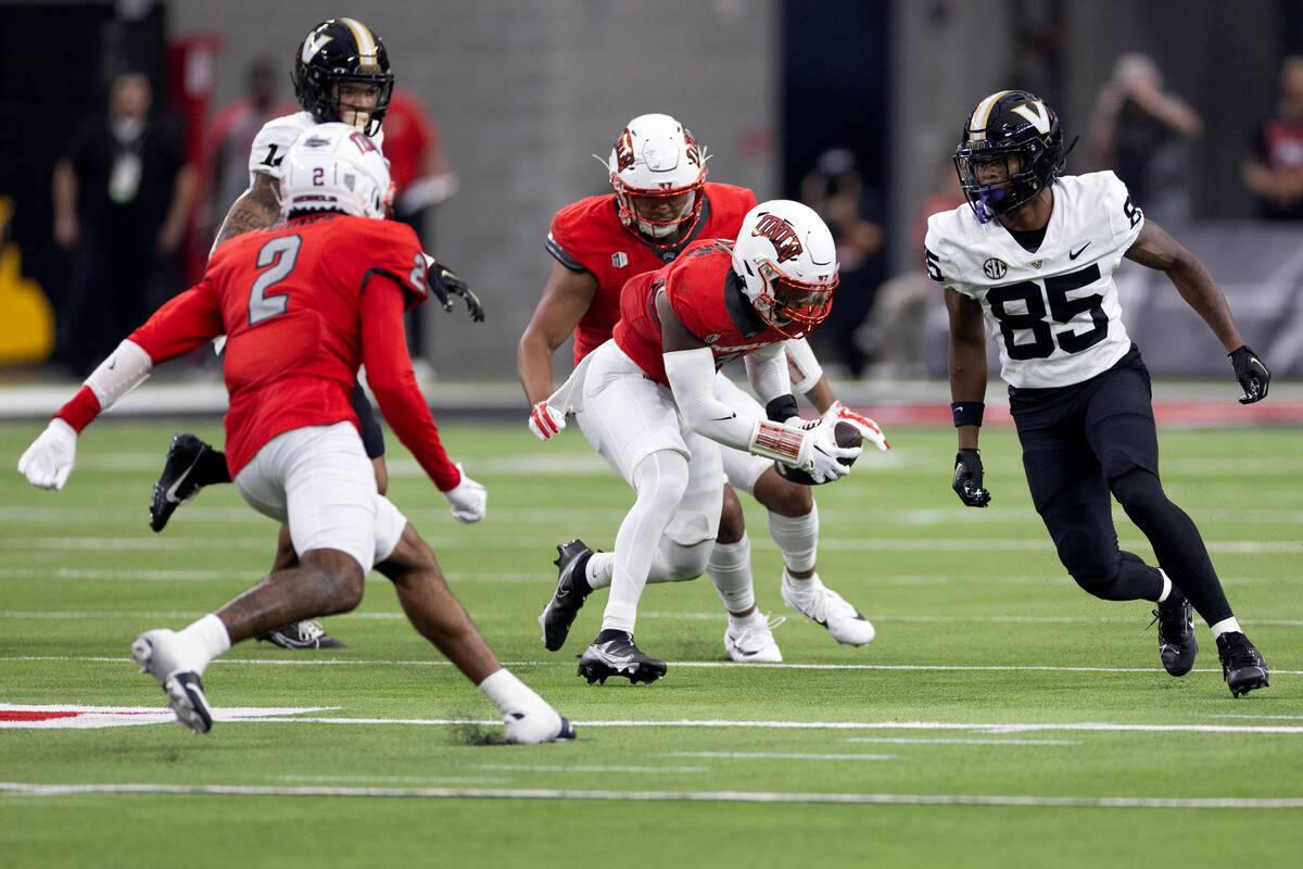 UNLV defensive back Jerrae Williams, center, recovers a fumble while Vanderbilt wide receiver ...