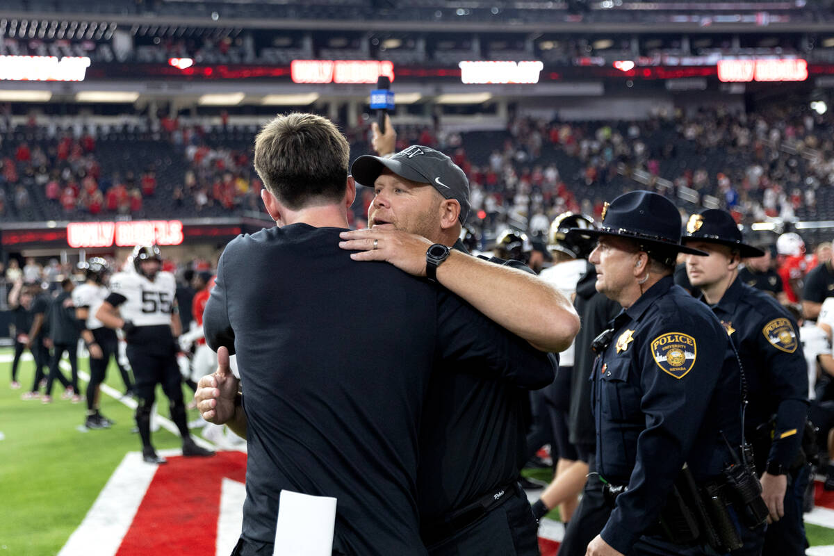 UNLV head coach Barry Odom hugs a fellow coach after his team won a NCAA college football game ...