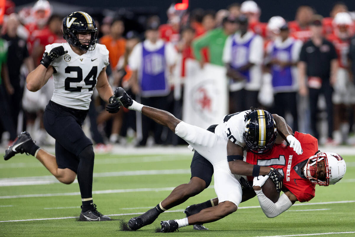 UNLV wide receiver Ricky White (11) is tackled by Vanderbilt safety Jalen Gilbert (38) during ...