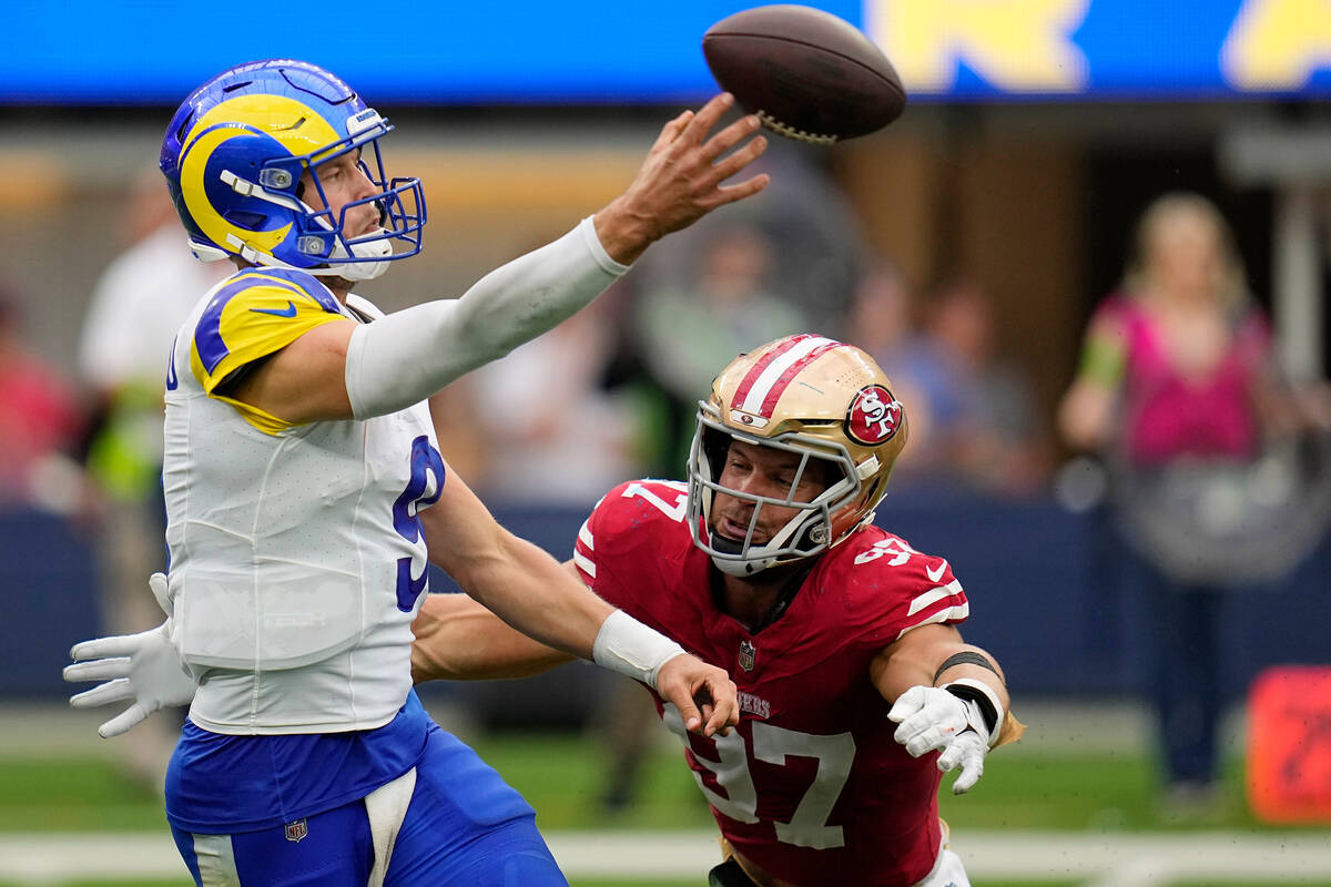 Los Angeles Rams quarterback Matthew Stafford, left, gets a pass off before San Francisco 49ers ...