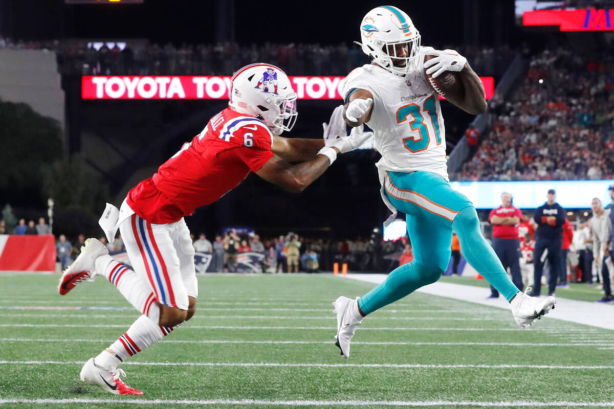 Miami Dolphins running back Raheem Mostert (31) out runs New England Patriots cornerback Christ ...