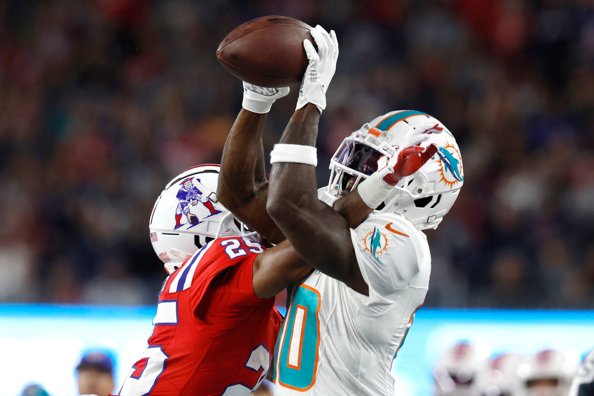 New England Patriots cornerback Marcus Jones (25) tries to break up a pass to Miami Dolphins wi ...