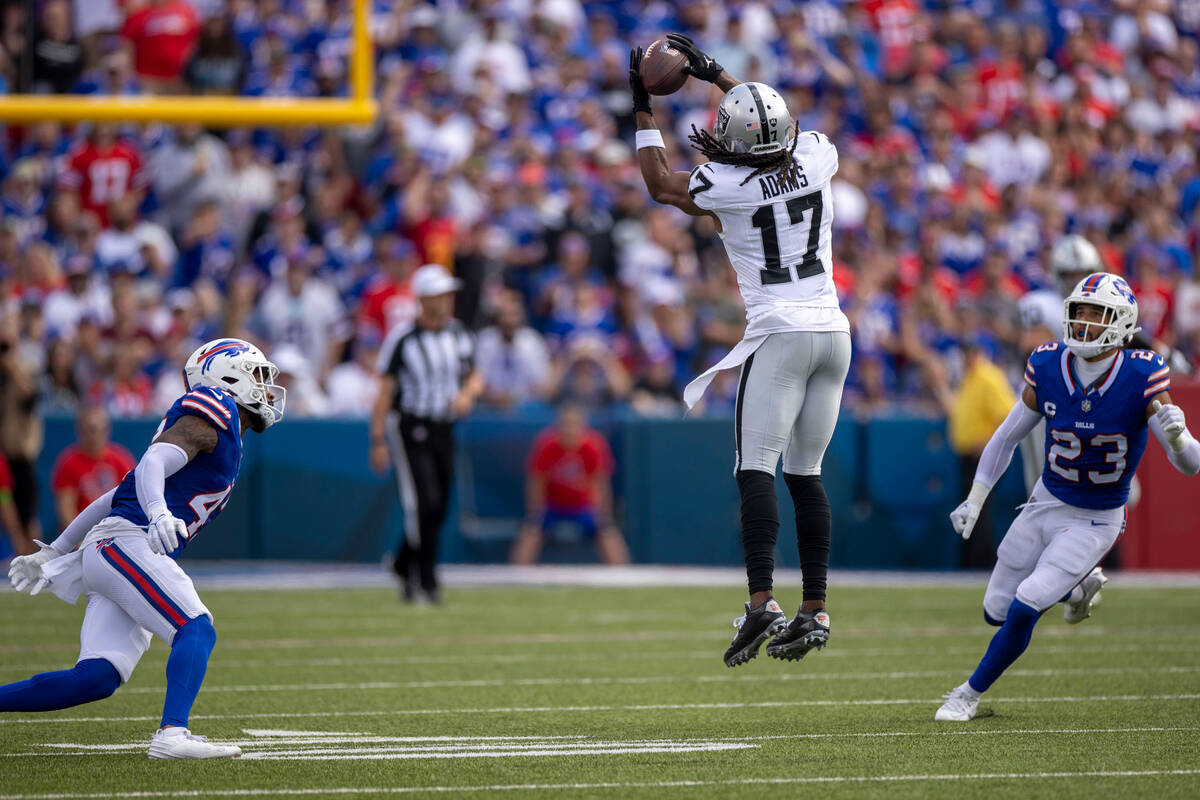 Raiders wide receiver Davante Adams (17) makes a leaping catch with Buffalo Bills safety Micah ...