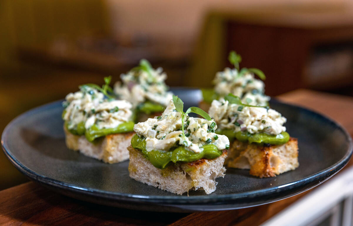 Miniature avocado sourdough toasts topped with avocado mousse, jumbo lump blue crab and green g ...