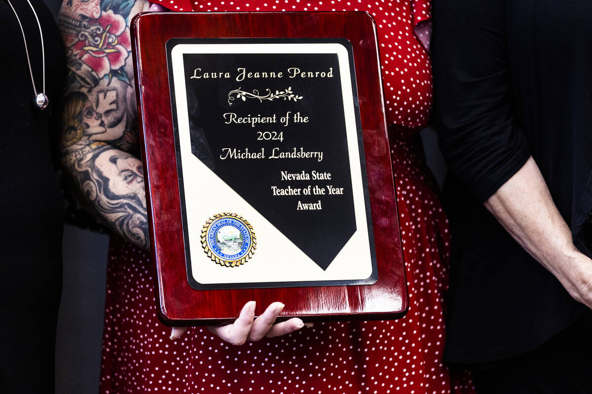Laura Penrod, an english teacher at Southwest Career and Technical Academy, holds her award for ...