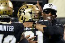 Colorado head coach Deion Sanders, right, hugs his son, safety Shilo Sanders, after he returned ...