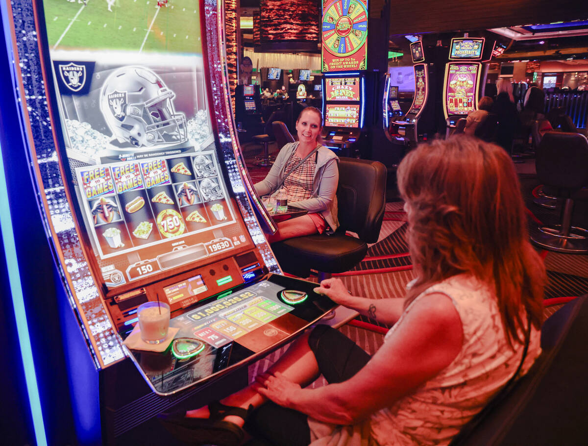 Pam Hillaker, right, of Idaho, plays the first Vegas NFL slot machine with her daughter Candice ...