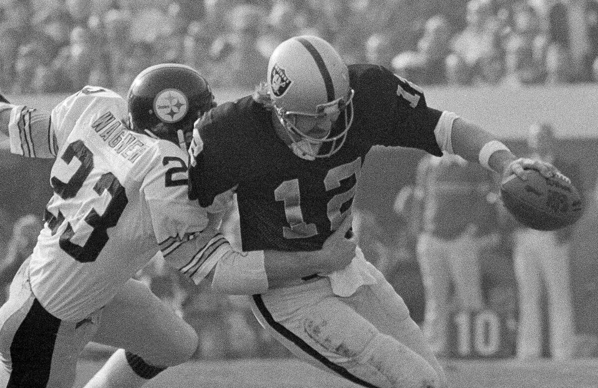 FILE - In this Dec. 26, 1976, file photo, Oakland Raiders quarterback Ken Stabler is tackled by ...