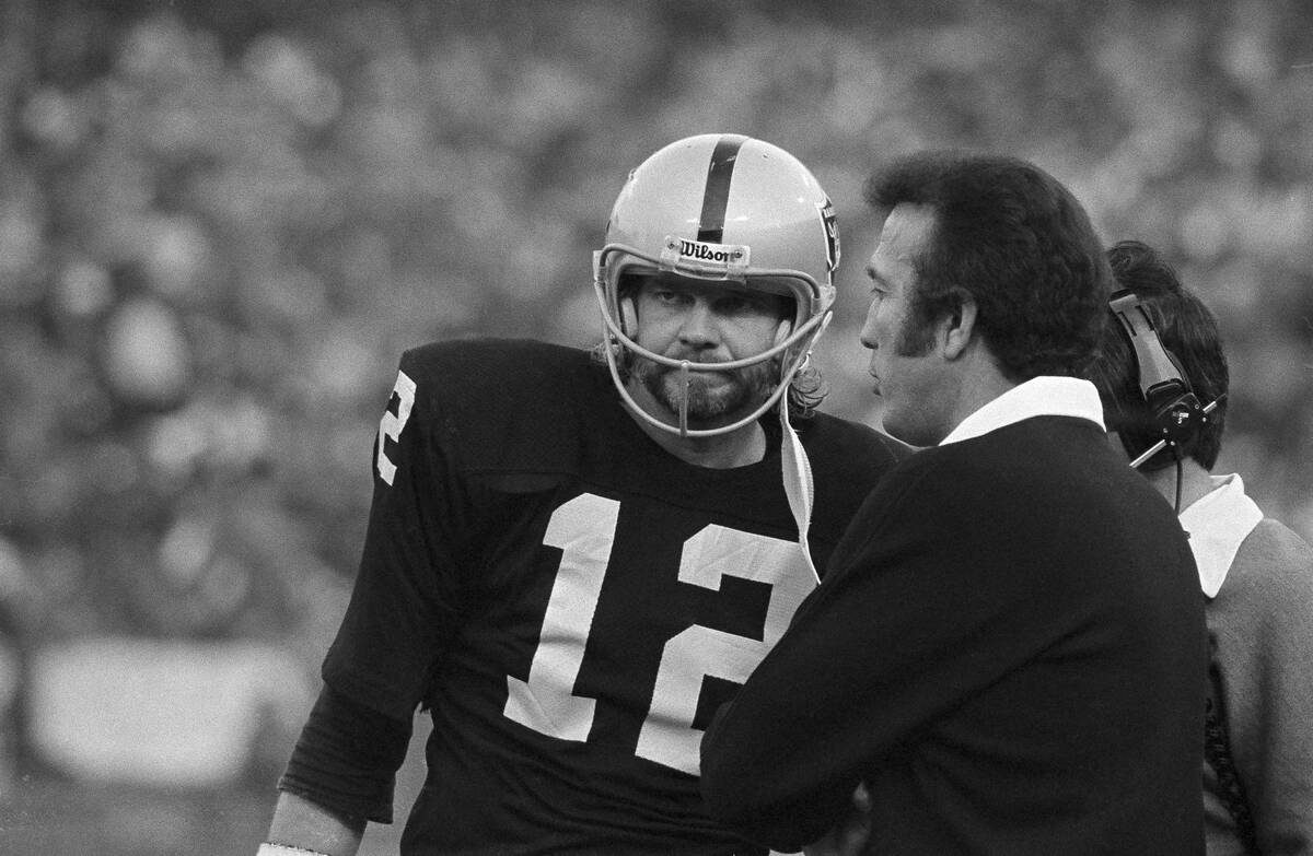Oakland quarterback Ken Stabler listens carefully as his coach Tom Flores discusses the situati ...