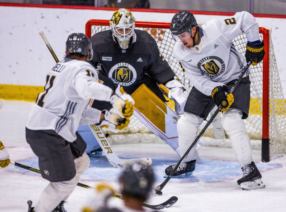 Golden Knights defenseman Zach Whitecloud (2) takes control of the puck in front of goalie Jiri ...
