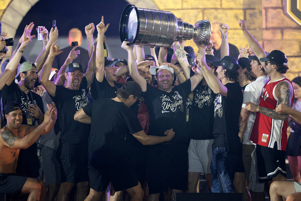 The Golden Knights rally around right wing Phil Kessel, holding the Stanley Cup, as they celebr ...