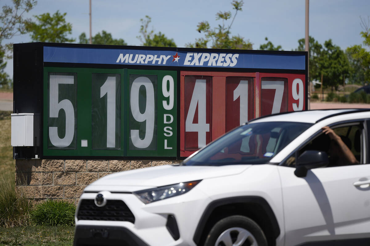 Gasoline prices are displayed outside a convenience store as a motorist drives by, Thursday, Ma ...