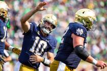 Notre Dame Sam Hartman (10) celebrates with Zeke Correll (52) during the second half of an NCAA ...