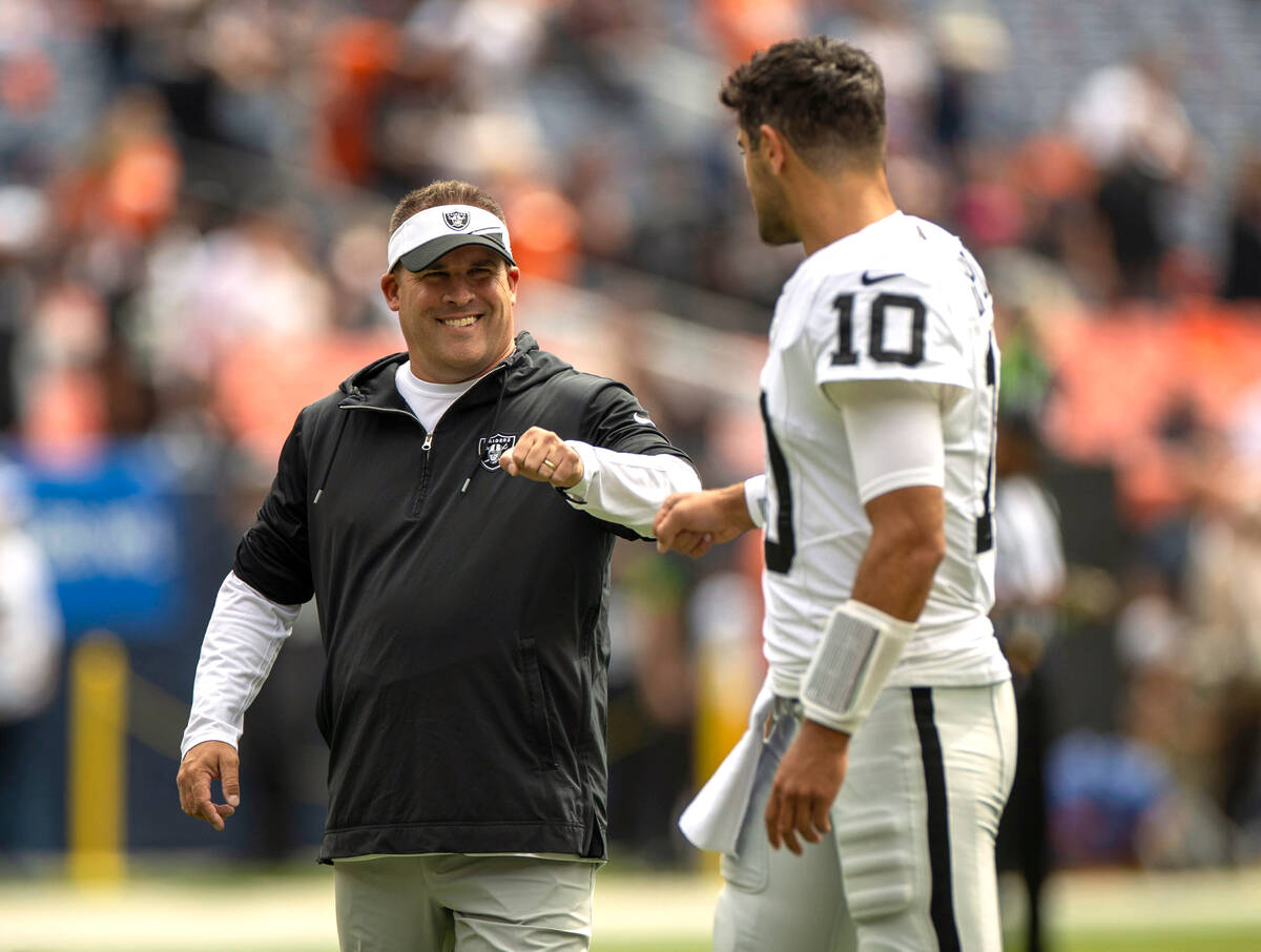 Raiders head coach Josh McDaniels meets with quarterback Jimmy Garoppolo (10) before the start ...