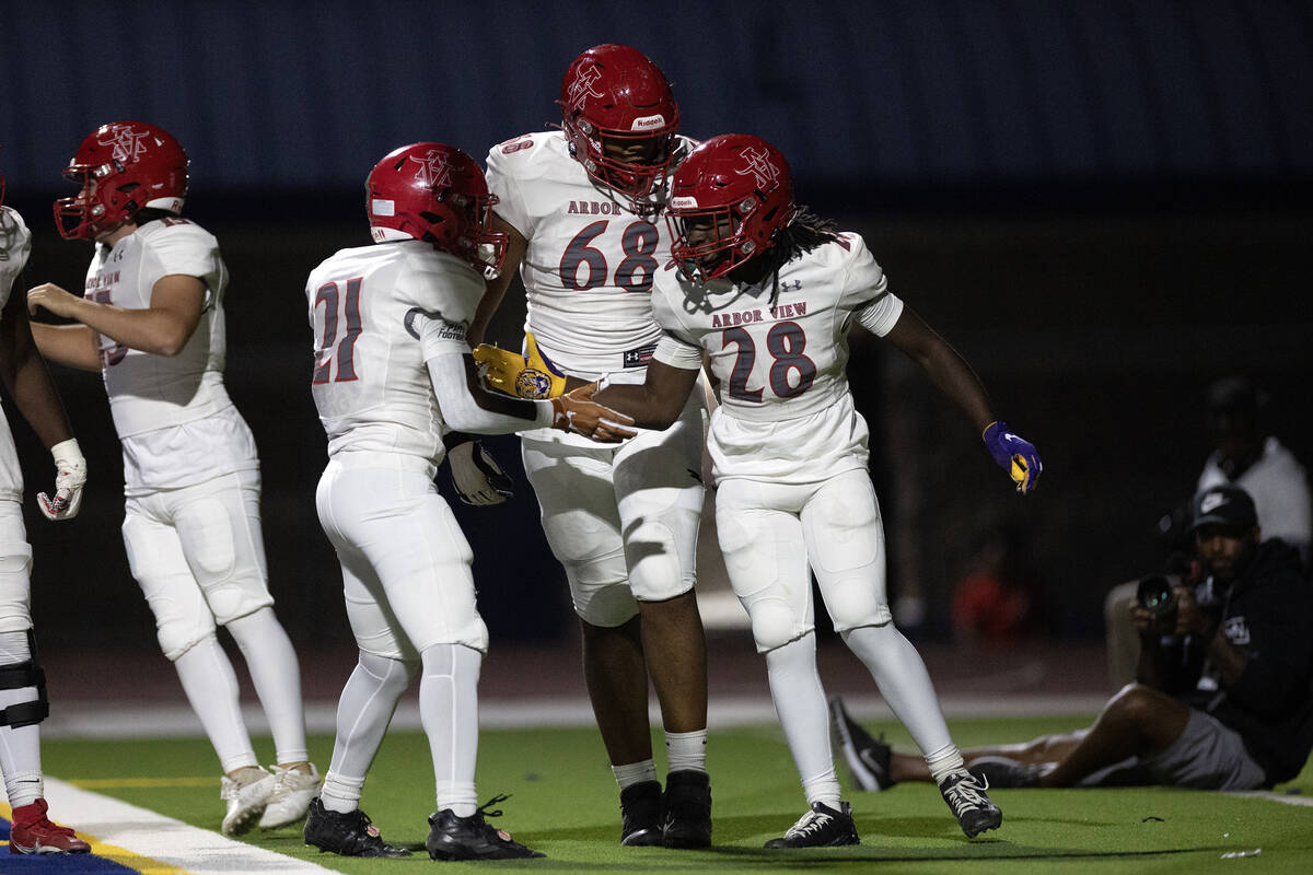 Arbor View running back Nylen Johnson (28) celebrates his touchdown with running back Sean Moor ...