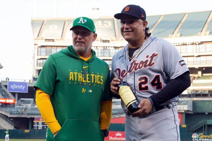 Oakland Athletics manager Mark Kotsay, left, presents a bottle of wine to Detroit Tigers design ...