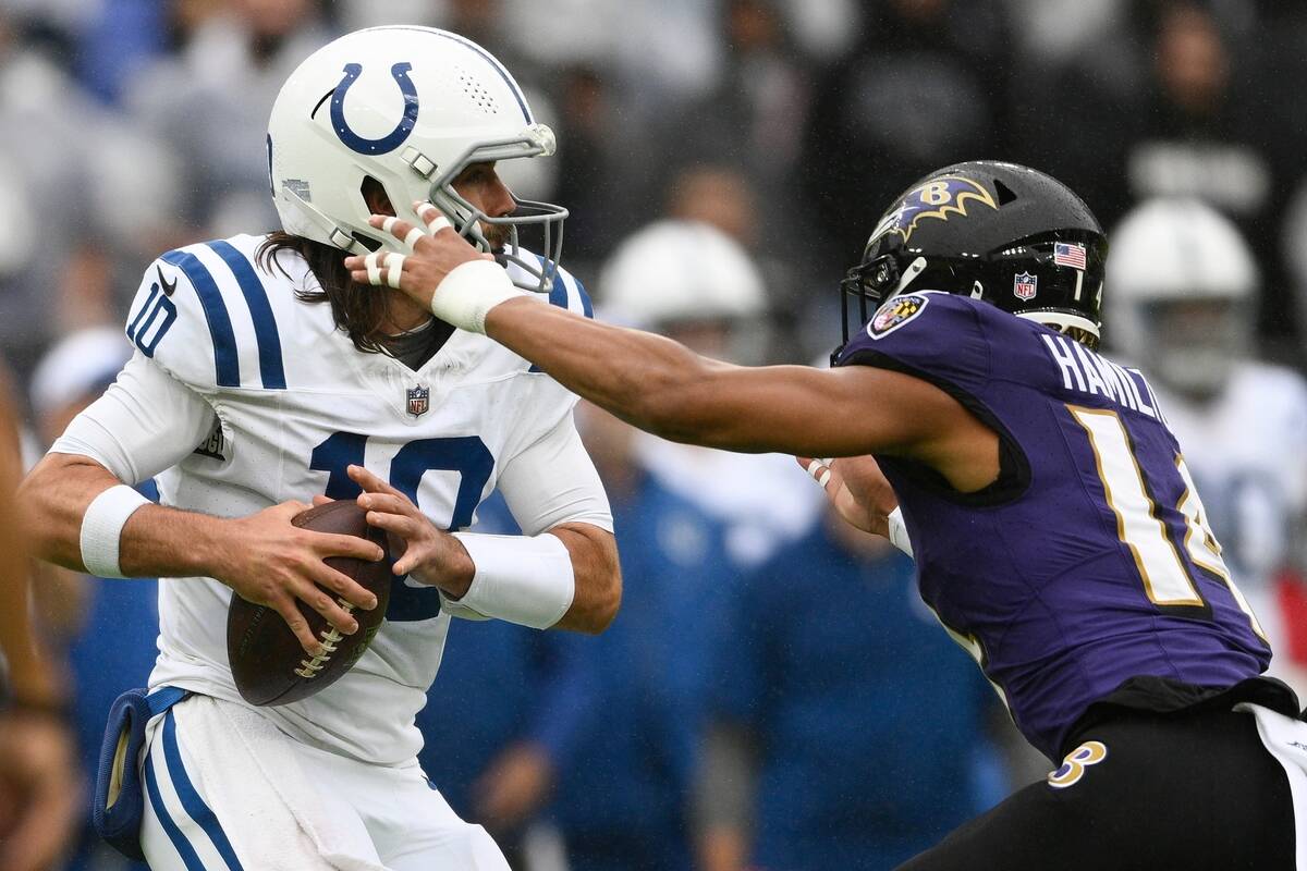 Indianapolis Colts quarterback Gardner Minshew is sacked by Baltimore Ravens' Kyle Hamilton dur ...