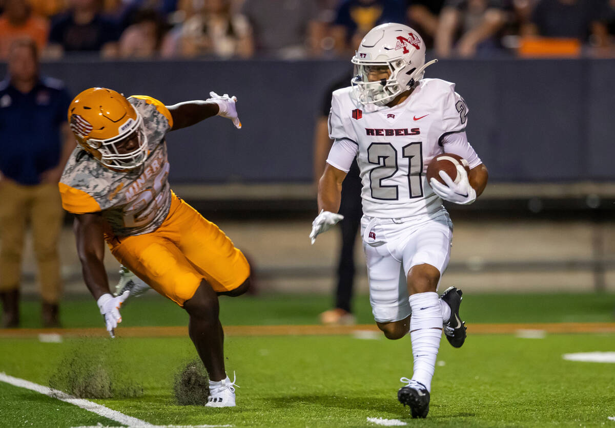 UNLV wide receiver Jacob De Jesus (21) runs for yardage chased by UTEP safety Lantz Russell dur ...