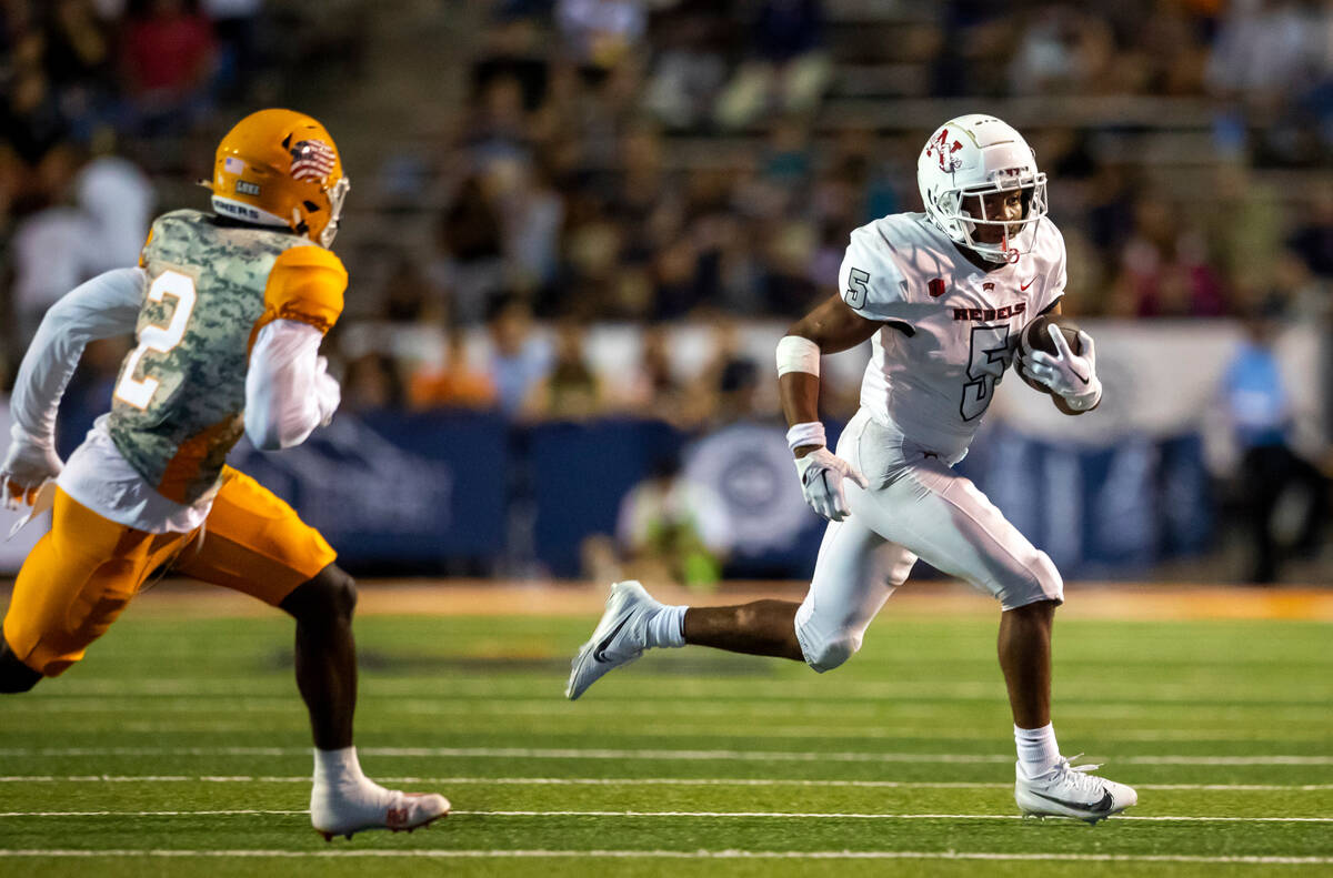 UNLV running back Vincent Davis Jr. (5) runs for yardage chased by UTEP safety Kobe Hylton (2) ...