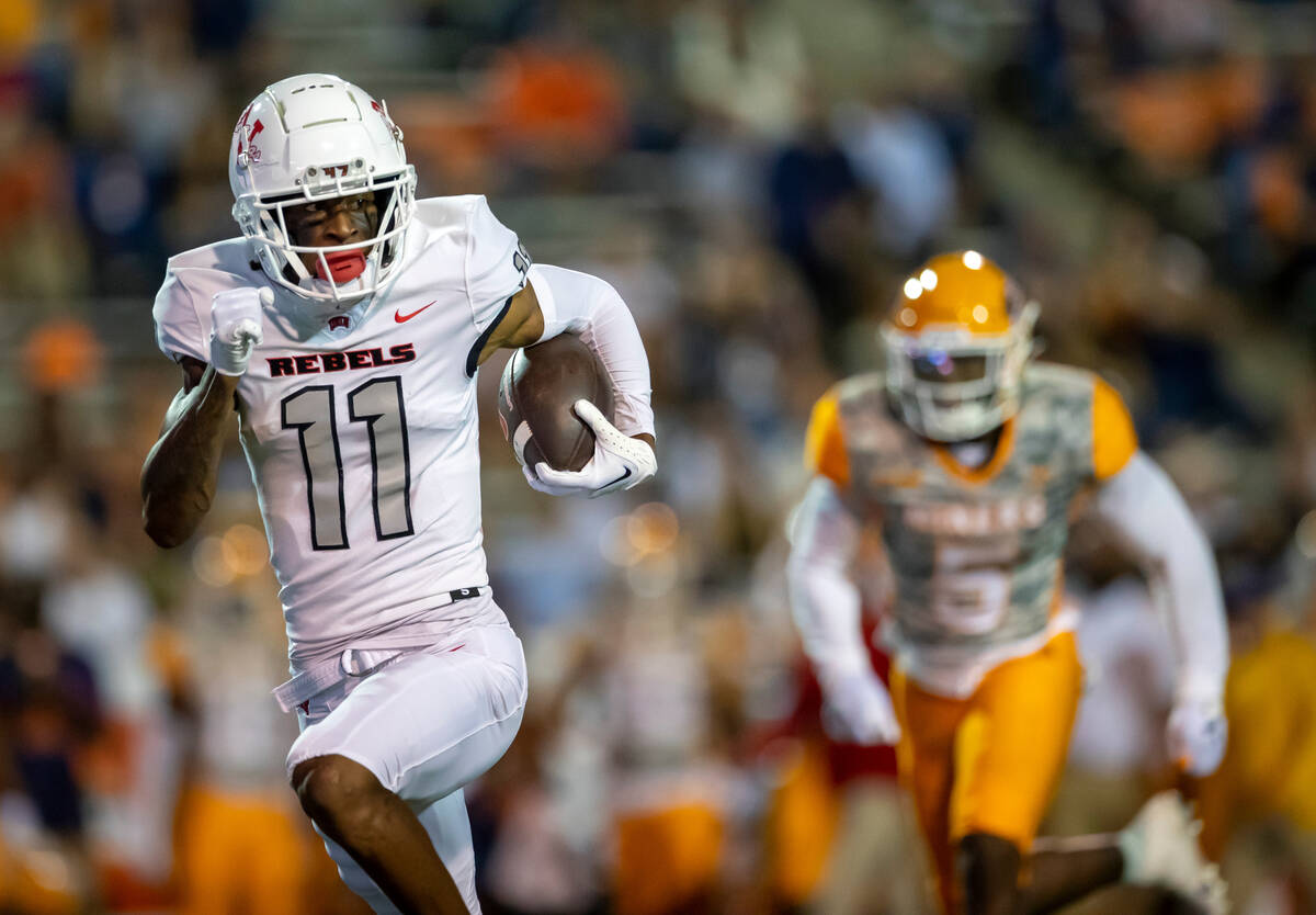 UNLV wide receiver Ricky White (11) runs for yardage as UTEP linebacker James Neal gives chase ...