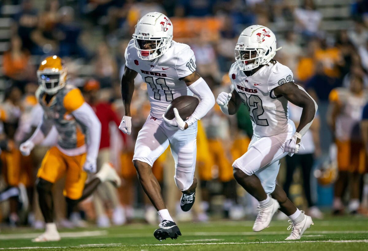 UNLV wide receiver Ricky White (11) carries the ball escorted by running back Jai'Den Thomas du ...