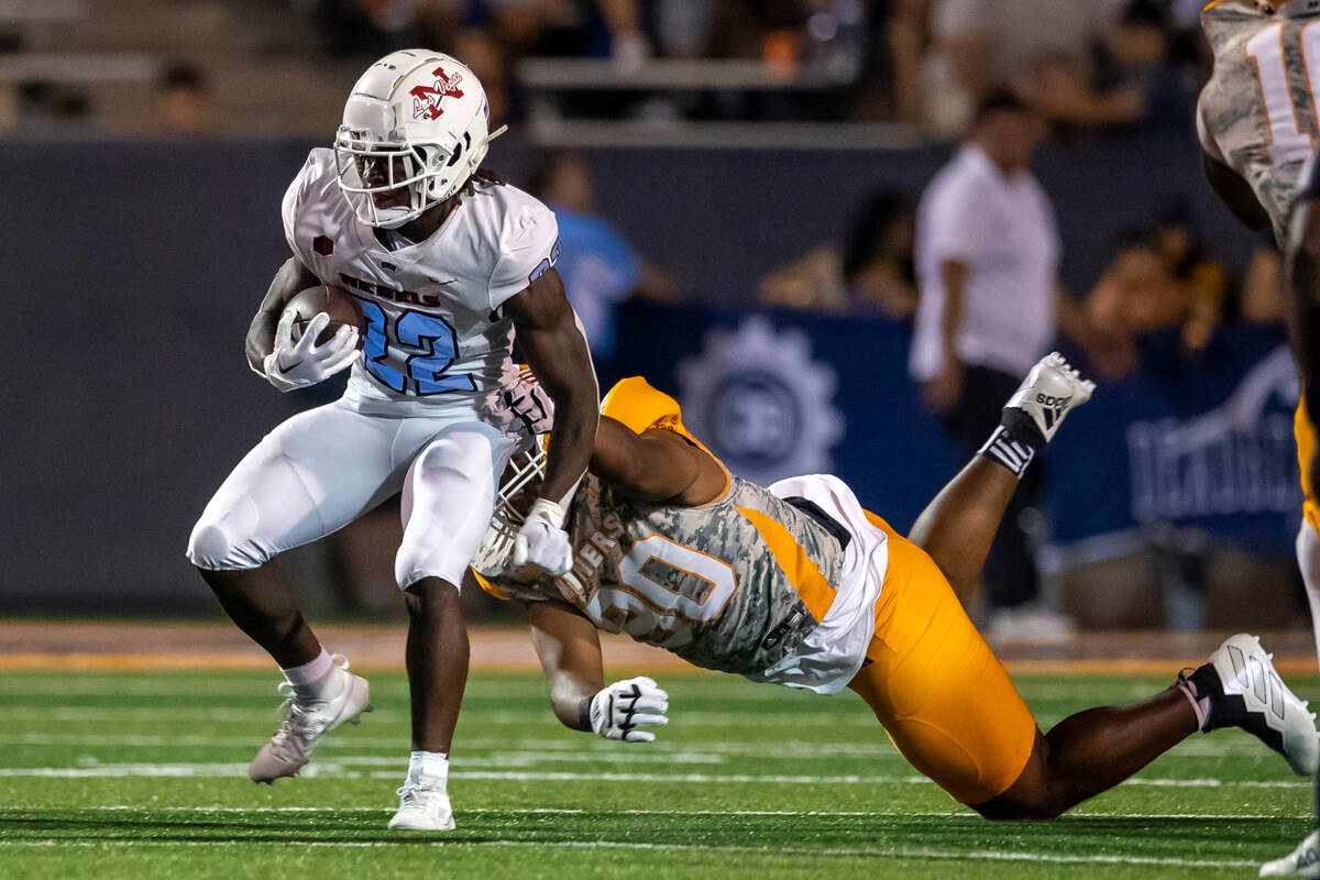 UNLV running back Jai'Den Thomas (22) is slowed by UTEP defensive lineman RaQuan Thompson durin ...