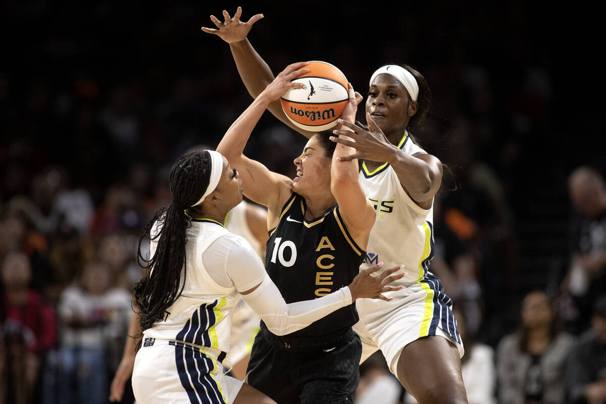 Las Vegas Aces guard Kelsey Plum (10) is pressured by Dallas Wings guard Odyssey Sims, left, an ...