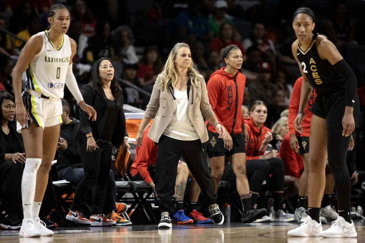 Las Vegas Aces head coach Becky Hammon, paces the sidelines between Dallas Wings forward Satou ...