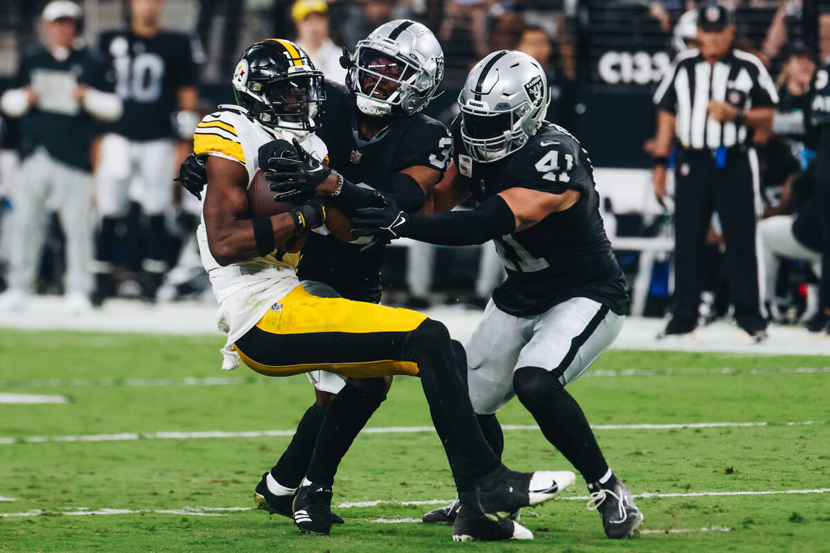 Pittsburgh Steelers wide receiver George Pickens (14) holds onto the ball as Raiders defensive ...