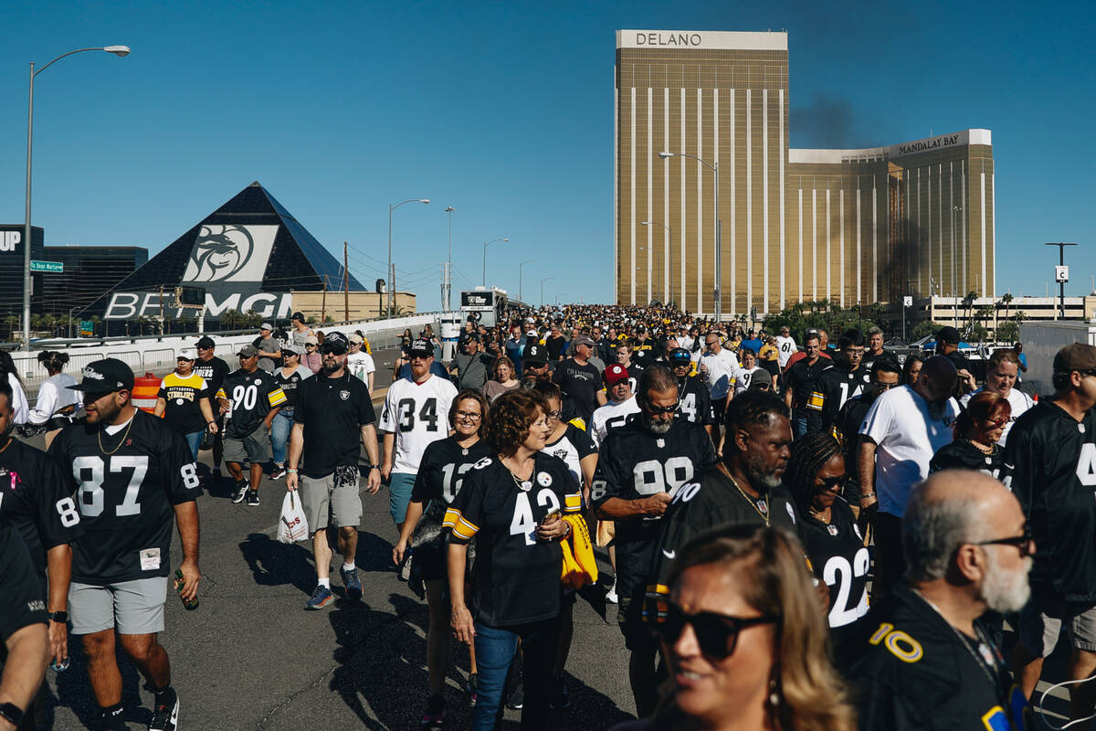 Fans walk across Mandalay Bay Road to get to the Raiders game at Allegiant Stadium on Sunday, S ...